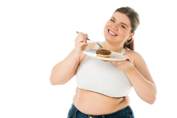 smiling overweight woman holding sweet doughnut on plate isolated on white, body positivity concept - Photo, Image