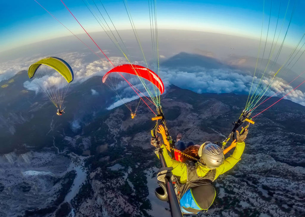 A paragliding az égen. Siklóernyő tandem repül át a tengeren, a kék víz és a hegyek, a ragyogó napsütéses napon. A légi felvétel a Siklóernyő és a Blue Lagoon, Oludeniz, Törökország. Extrém sport. Táj - Fotó, kép