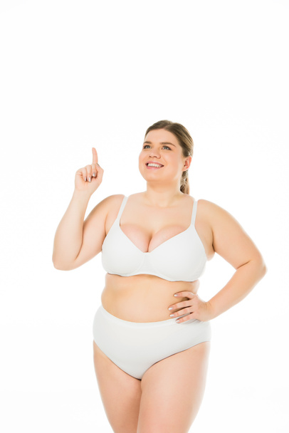 smiling overweight girl in underwear showing idea sign isolated on white, body positivity concept  - Zdjęcie, obraz