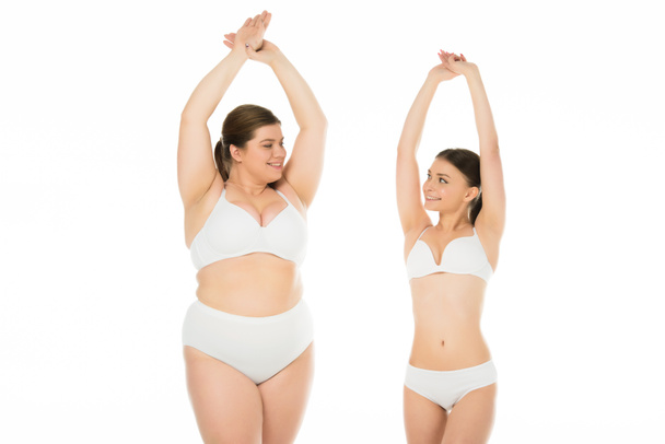 jeunes femmes minces et en surpoids en sous-vêtements posant ensemble isolé sur blanc, concept de positivité du corps
 - Photo, image