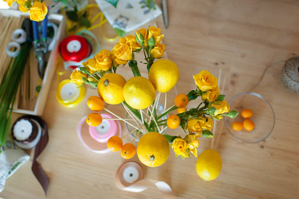 Floristics hobby. Floral and fruits bouquet making process. - 写真・画像