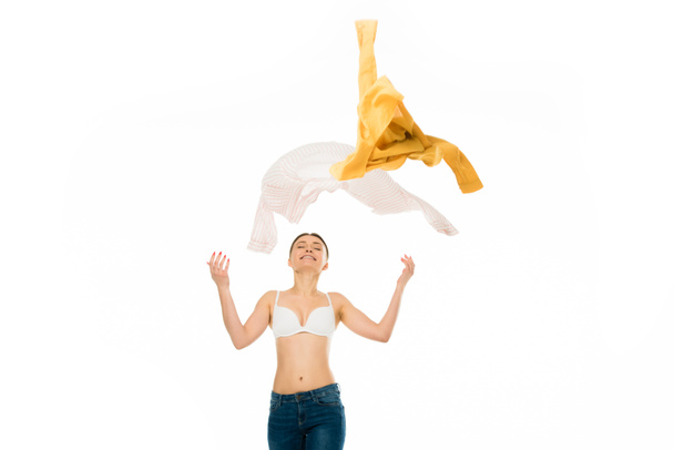 slim happy woman in underwear and blue jeans throwing up clothing isolated on white - Fotografie, Obrázek