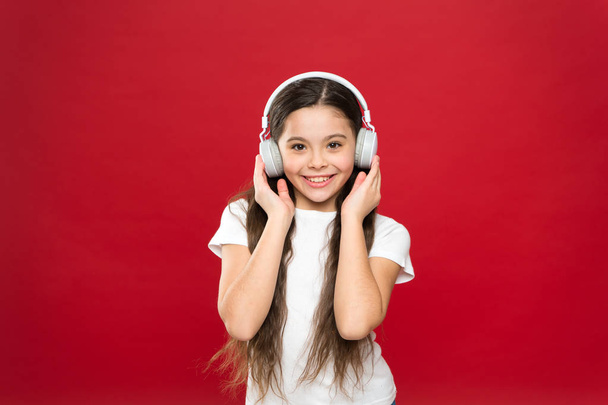 Music taste. Music plays an important part lives teenagers. Powerful effect music teenagers their emotions, perception of world. Girl listen music headphones on red background. Play list concept - Fotografie, Obrázek