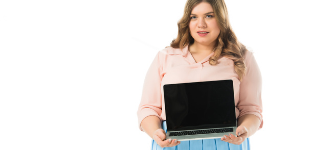 mooie elegante plus grootte meisje toont laptop met leeg scherm geïsoleerd op wit - Foto, afbeelding