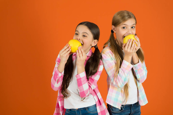 School lunch. Vitamin fruit nutrition for children. Healthy lifestyle. Distributing free fresh fruit at school. Girls kids casual style eat apple fruit orange background. Schoolgirls eat apple fruit - Foto, immagini
