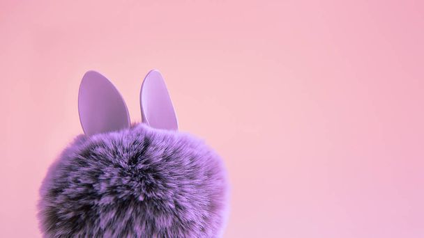 Fur ball with bunny rabbit ears on bright background. Easter minimal concept - Fotoğraf, Görsel