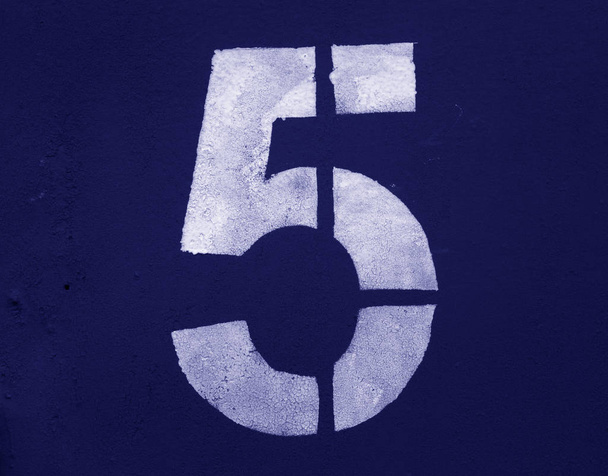 Νούμερο 5 σε στένσιλ σε μεταλλικό τοίχο σε μπλε τόνο. - Φωτογραφία, εικόνα