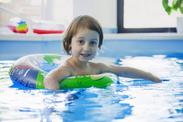 Funny portrait of happy cute little girl in swimming pool. Child - Фото, изображение