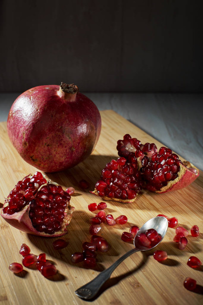 Juicy pomegranate on a wooden board.  - Fotoğraf, Görsel