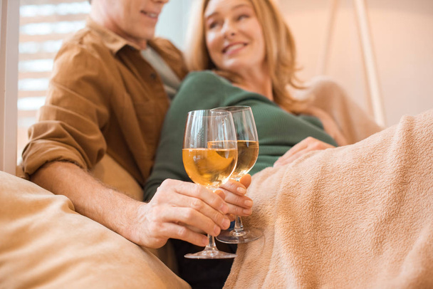 selective focus of happy couple holding glasses of white wine  - Photo, Image