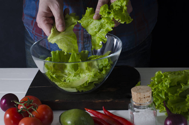 L'homme prépare une salade verte de laitue romaine. Concept d'alimentation saine
 - Photo, image