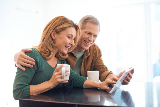 happy couple with coffee cups using digital tablet - Φωτογραφία, εικόνα