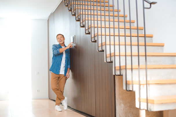 good-looking man using smart house control panel at new home - 写真・画像