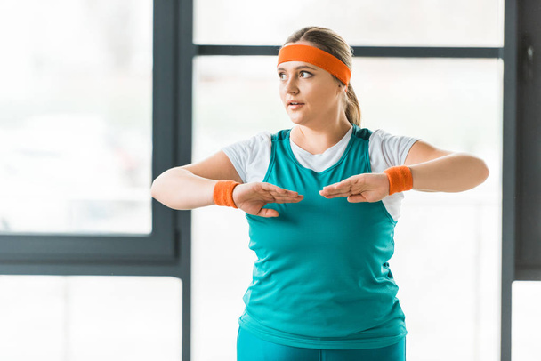 atractiva mujer con sobrepeso haciendo ejercicio en ropa deportiva en el gimnasio
 - Foto, Imagen