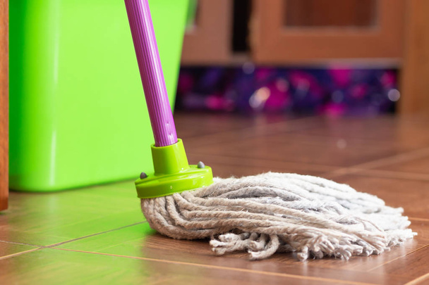 Rope mop for cleaning the floor on the background of a plastic bucket - Foto, imagen