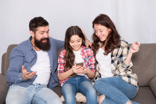 Child share news with mother and father. Little girl child use mobile phone. Happy family at home. Buy online. Child with childhood happiness. bearded man and woman with child. Family bonds - Zdjęcie, obraz