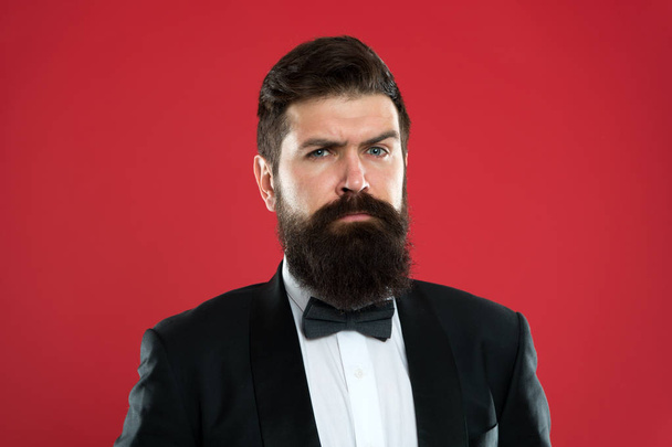 Classy style. Man bearded hipster wear classic suit outfit. Take good care of suit. Elegancy and male style. Businessman or host fashionable outfit on red background. Fashion concept. Formal outfit - Photo, Image
