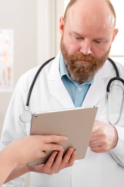 Orvosok megvitatása jelentést egy beteg táblagépen a kórházban - Fotó, kép