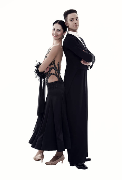 Fashion couple pose isolated on white. Couple in love of ballroom dancers. Sexy woman in black dress and confident man in tuxedo. Valentines day concept. Love date or proposal and family - Fotó, kép