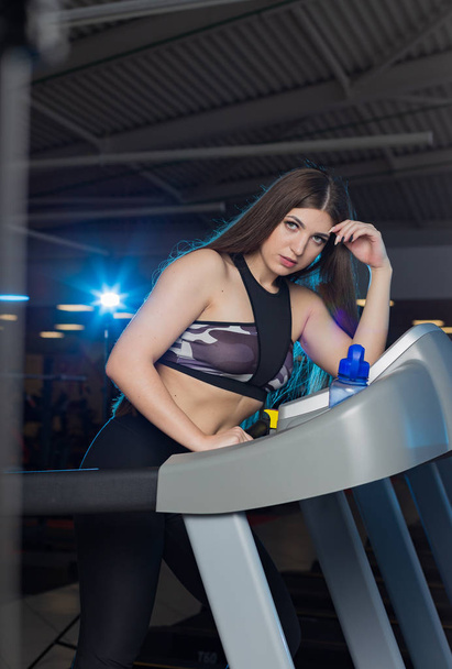 Vonzó fiatal sport nő dolgozik az edzőteremben. Ezzel görbe futópad kardioedzés. Nem motoros futópad futás. - Fotó, kép