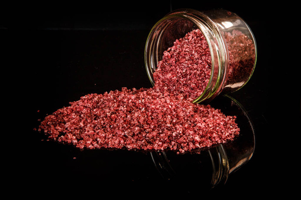 big red organic sea salt poured out from small glass jar - Photo, Image