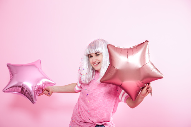 lustiges Mädchen mit silbernem Haar gibt ein Lächeln und Emotionen auf rosa ba - Foto, Bild