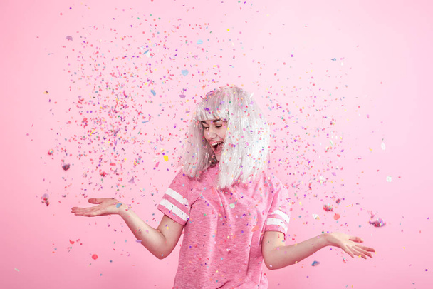 Grappig meisje met zilveren haren geeft een glimlach en emotie op roze ba - Foto, afbeelding