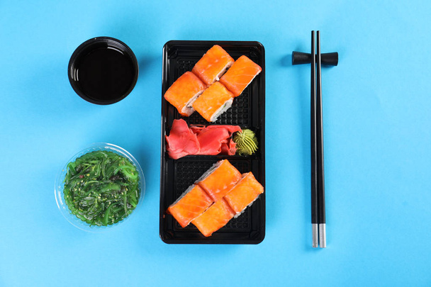 Flat lay composition with sushi rolls on color background. Food delivery - Zdjęcie, obraz