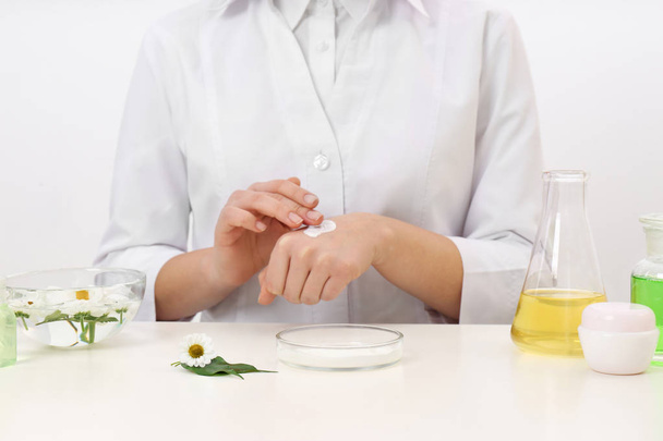 Female dermatologist testing skin care product at table, closeup - Фото, зображення