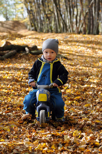 Портрет щасливого маленького хлопчика, що їде на мотоциклі
 - Фото, зображення