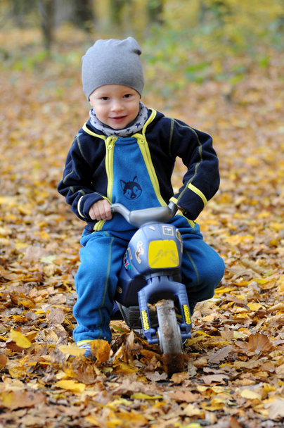 Porträt eines glücklichen kleinen Jungen auf einem Motorrad - Foto, Bild