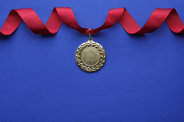 Gold medal with space for design on color background, top view. Victory concept - 写真・画像