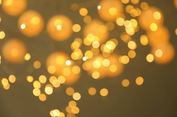 Blurred view of gold lights on dark background. Bokeh effect - Photo, Image