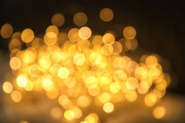 Gold glitter with bokeh effect on dark background - Photo, image