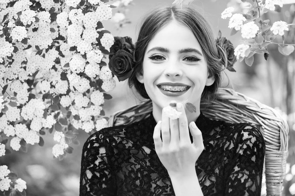 woman smiling with white flower in mouth - Foto, imagen