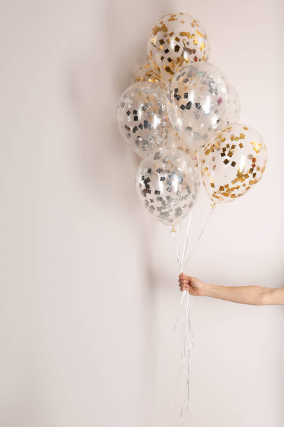 Woman holding bunch of balloons on white background, closeup - Fotoğraf, Görsel