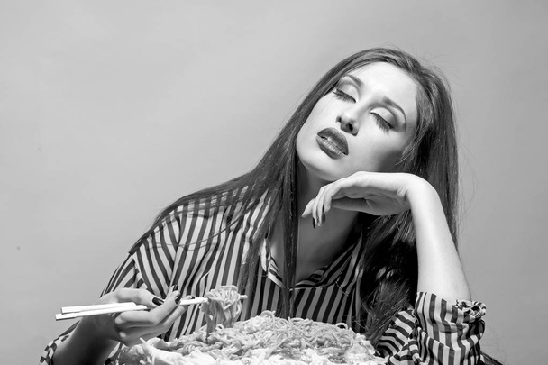Woman eat spaghetti with chopsticks. Woman eat pasta dish with tomato ketchup - Valokuva, kuva