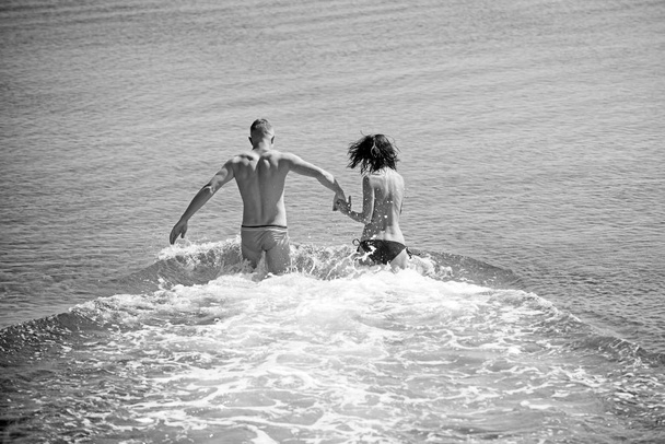 happy young couple having fun, man and woman in the sea on the beach. - Photo, image