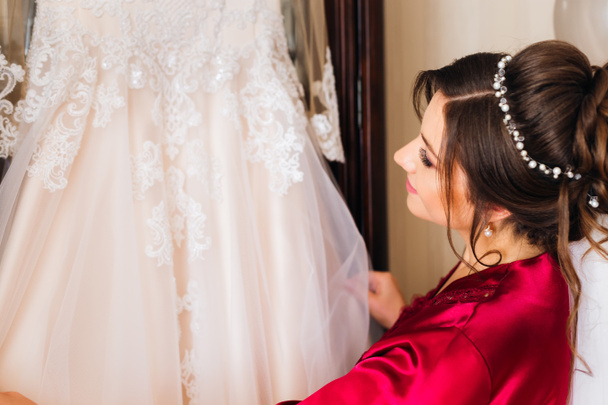 schönes weißes Kleid für die Braut, das am Kleiderschrank hängt. Die b - Foto, Bild