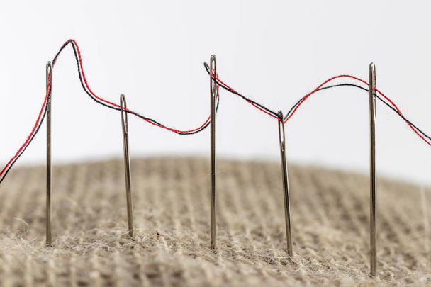 macro de primer plano en hilos de coser en aberturas de aguja
 - Foto, imagen