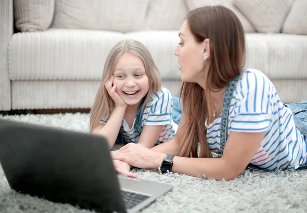 mother and daughter using a laptop in their home - Photo, image