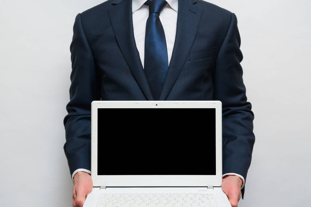 Portátil con pantalla en blanco, el hombre está sosteniendo la pantalla frente a la cámara
 - Foto, imagen