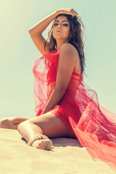 Fashion portrait of a young girl in a red dress on the beach. Su - Foto, Bild
