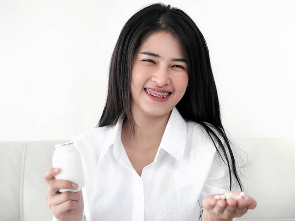 Asian woman holding pills on hand. Medicine and health care conc - Фото, изображение