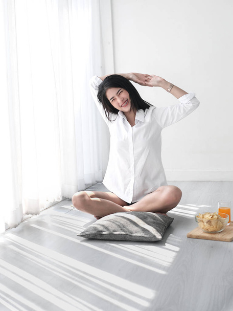 Attractive Asian girl sitting in white room and relax in weekend - Фото, зображення