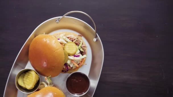 Flat lay. BBQ pulled pork sandwich with coleslaw on brioche buns. - Footage, Video
