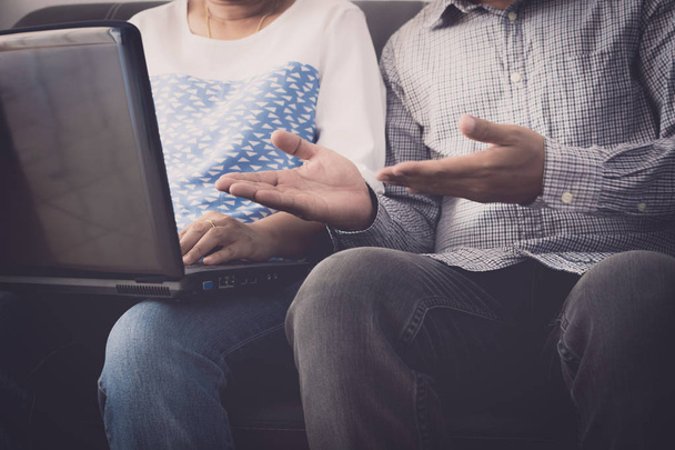 Άνδρας και γυναίκα workmate συζητώντας μαζί ενώ χρησιμοποιείτε το φορητό υπολογιστή σε - Φωτογραφία, εικόνα