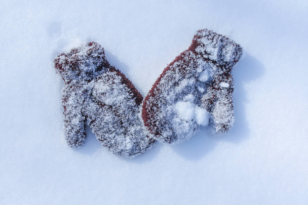Manoplas cálidas para niños marrones en la superficie de nieve
. - Foto, Imagen