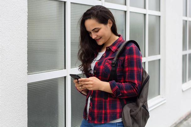 young girl student in a campus uses a mobile phone - Valokuva, kuva