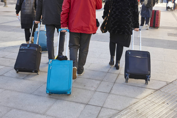 Путешественники ходят с багажом по улице. Городской образ жизни
 - Фото, изображение